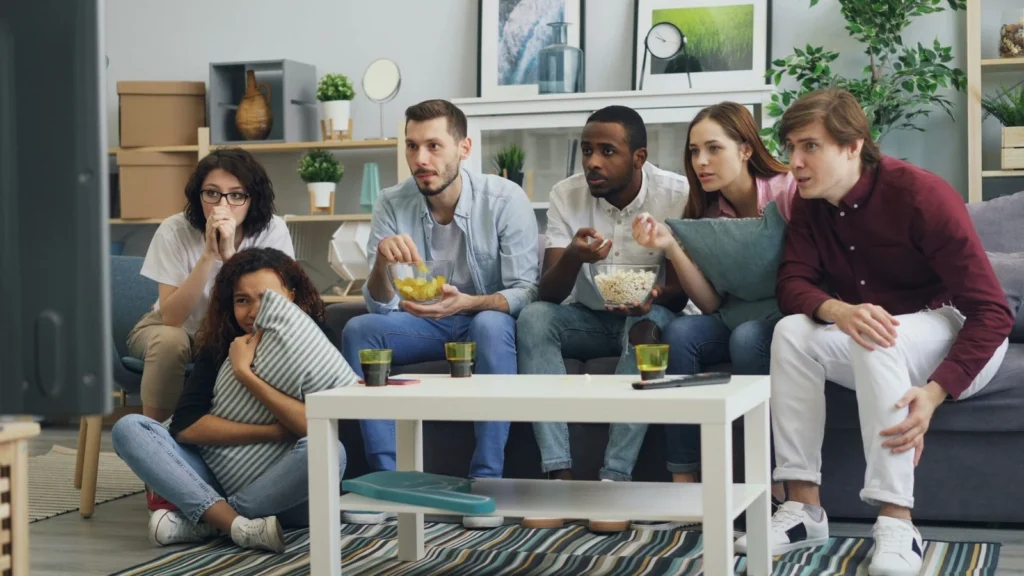 Diverse family watching entertainment on TV together in cozy living room